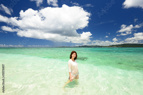 水納島のビーチで遊ぶ笑顔の女性 