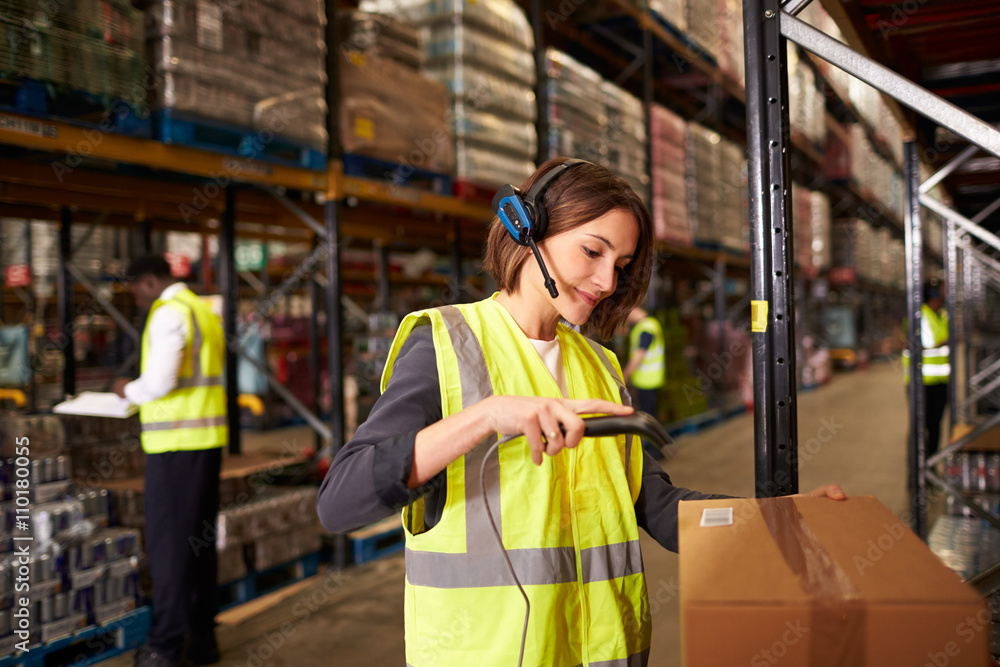 Woman using a barcode reader in a distribution warehouse Woman using a barcode reader in a distribution warehouse