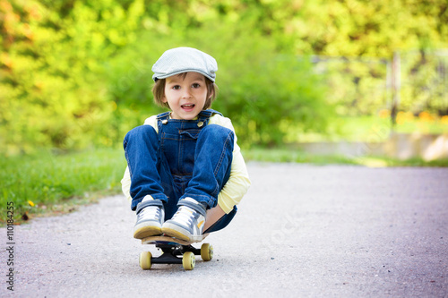 Adorable preschool child skateboarding on the street
