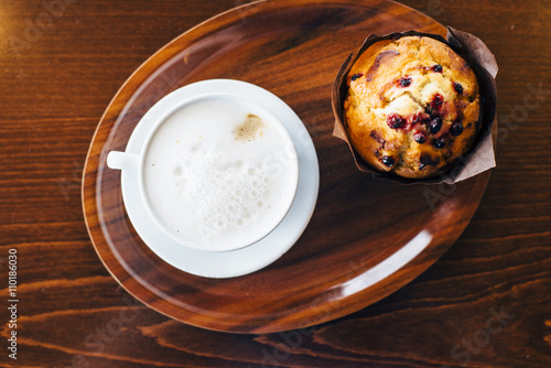 Cup of cappuccino and muffin on tray on wooden table © anna_rostova
