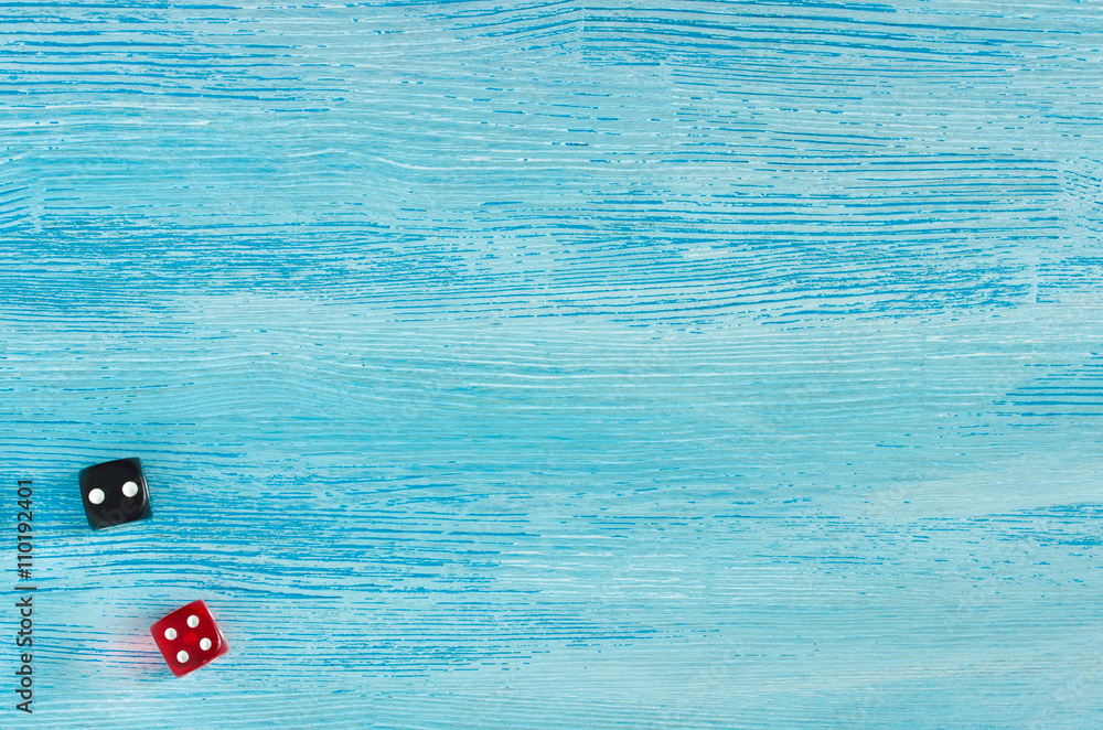 Red and black dice on old worn blue wooden background. Top view Red and black dice on old worn blue wooden background. Top view