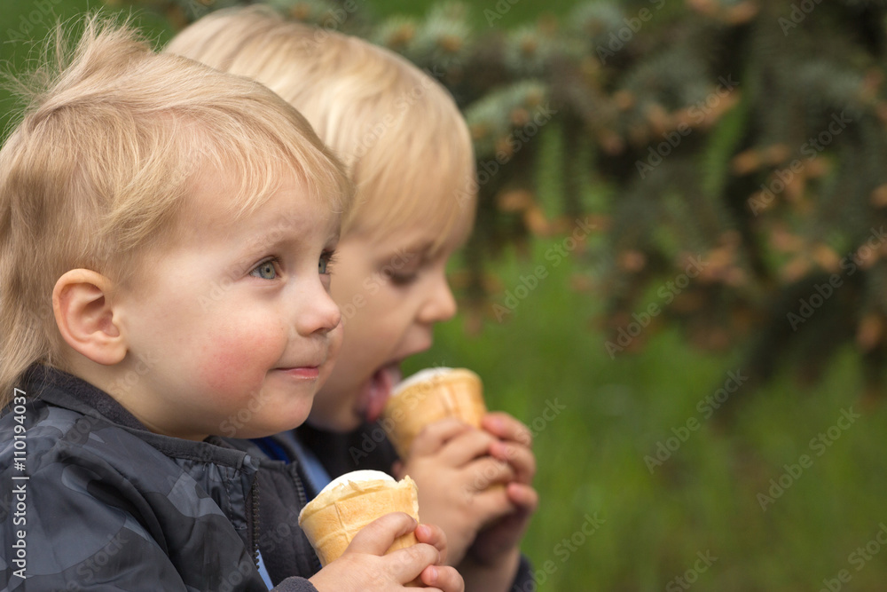 Happy twins eating an ice cream Happy twins eating an ice cream