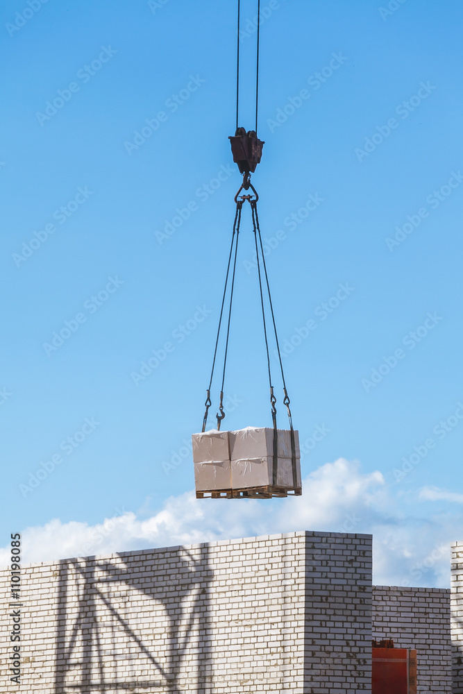 heavy load hanging on construction site of brick building