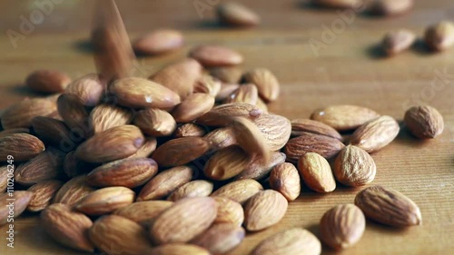 Almonds falling on a wooden floor.