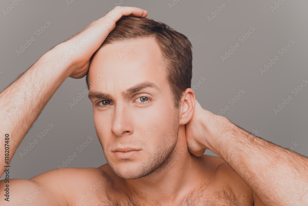 Portrait of young man combing his hair with fingers Portrait of young man combing his hair with fingers