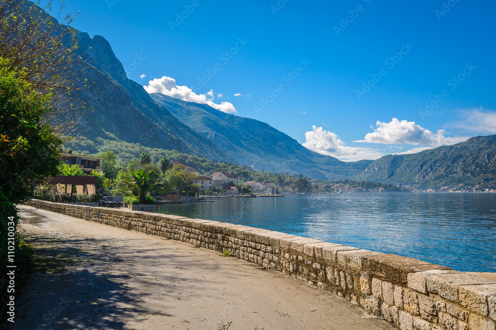Harbor and ancient buildings in sunny day at Boka Kotor bay (Boka Kotorska), Montenegro, Europe.