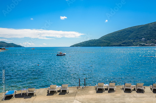 Harbor and beach in sunny day at Boka Kotor bay (Boka Kotorska), Montenegro, Europe.