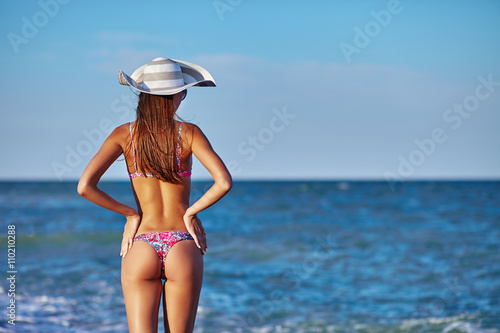 Sexy back of a beautiful woman in bikini on sea background. Sexy buttocks. Exotic country travel and rest concept.