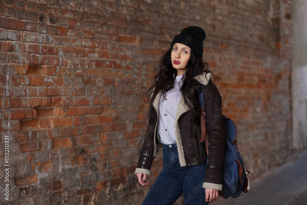 Outdoor lifestyle portrait of pretty young girl, wearing hipster swag grunge style on urban background. Wearing hat and jeans with backpack. Spring fashion woman. Toned style instagram filters. Outdoor lifestyle portrait of pretty young girl, wearing hipster swag grunge style on urban background. Wearing hat and jeans with backpack. Spring fashion woman. Toned style instagram filters.