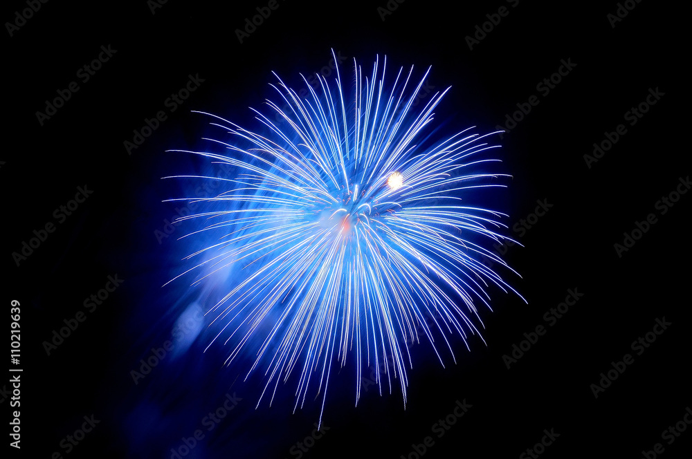 Flashes of blue fireworks and blue smoke against the black sky Flashes of blue fireworks and blue smoke against the black sky