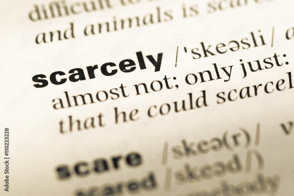 Close up of old English dictionary page with word scarcely Close up of old English dictionary page with word scarcely