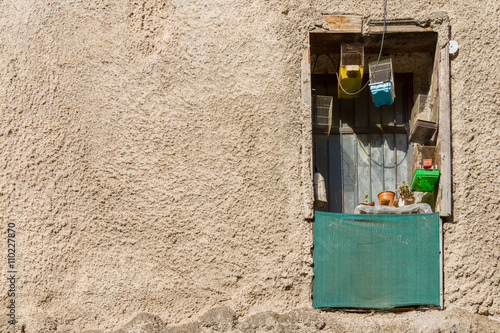 Derelict window, flower-pots and bird cages in an old building i photo