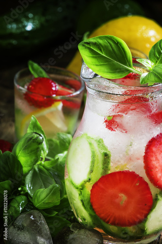 Cucumber basil lemonade with strawberries and ice in a pitcher,