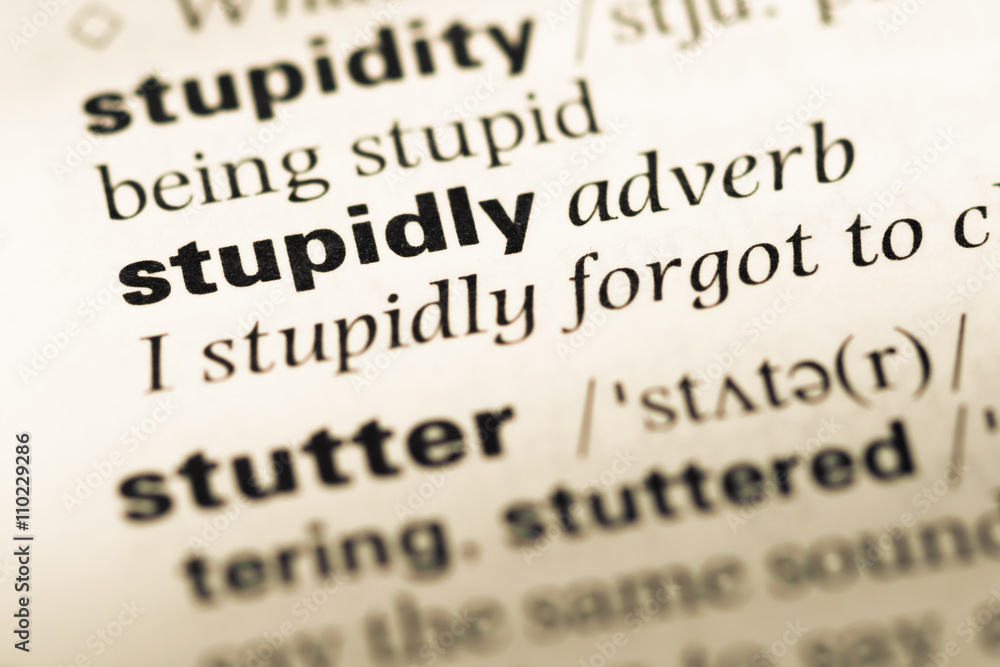 Close up of old English dictionary page with word stupidly Close up of old English dictionary page with word stupidly