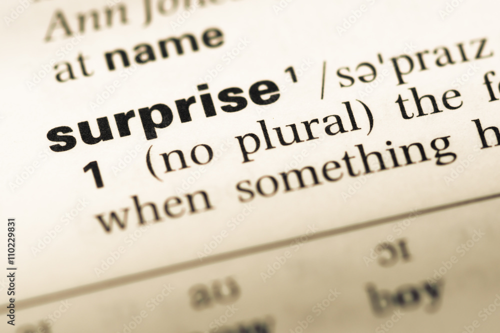 Close up of old English dictionary page with word surprise Close up of old English dictionary page with word surprise