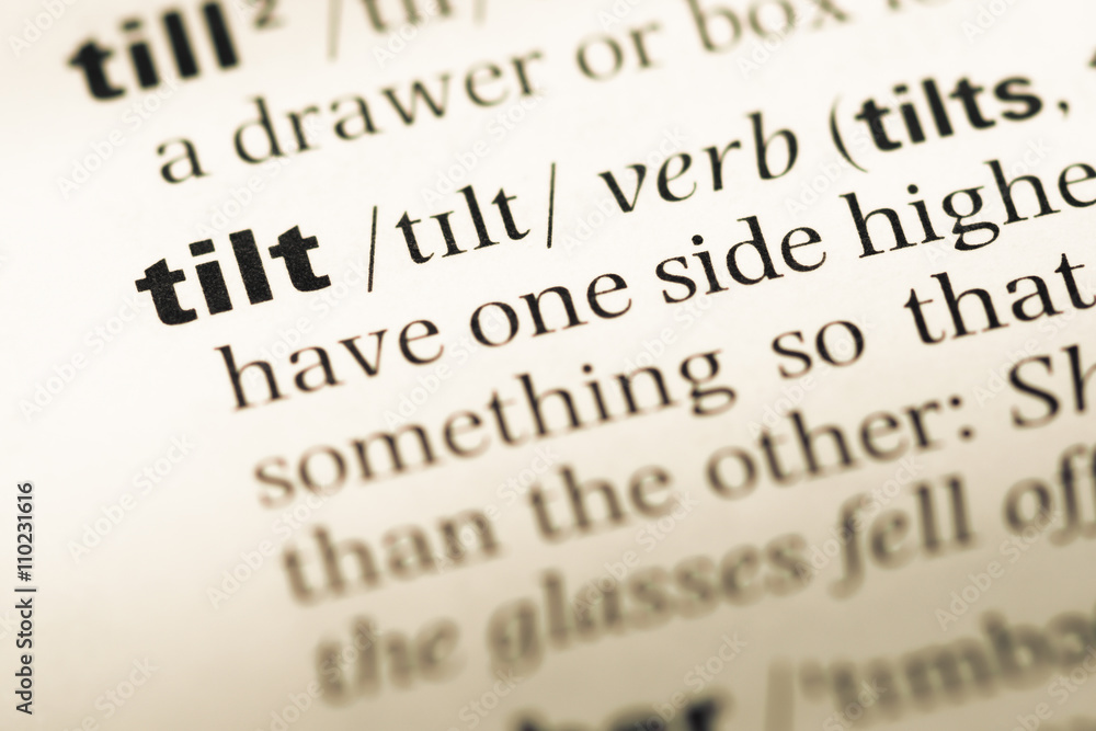 Close up of old English dictionary page with word tilt Close up of old English dictionary page with word tilt