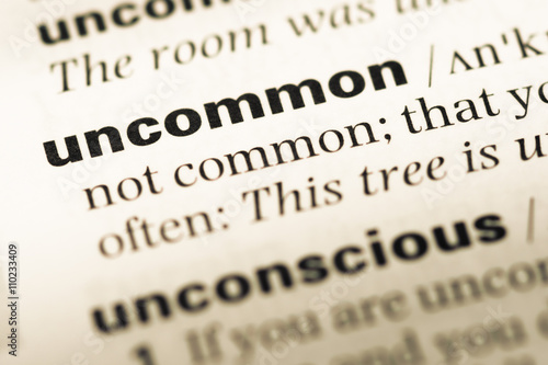 Close up of old English dictionary page with word uncommon