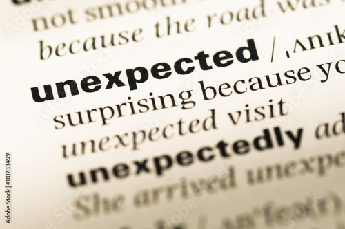 Close up of old English dictionary page with word unexpected