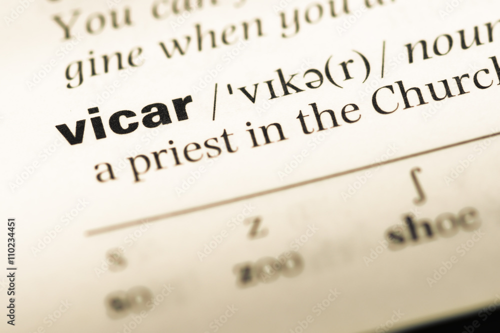 Close up of old English dictionary page with word vicar Close up of old English dictionary page with word vicar