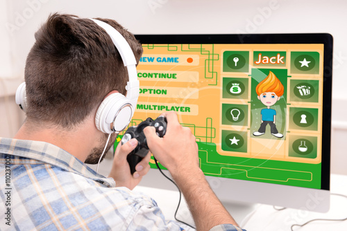 Young man playing computer ...