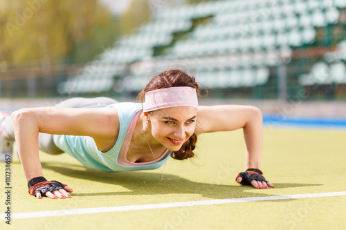 Young attractive woman doing push-up or core