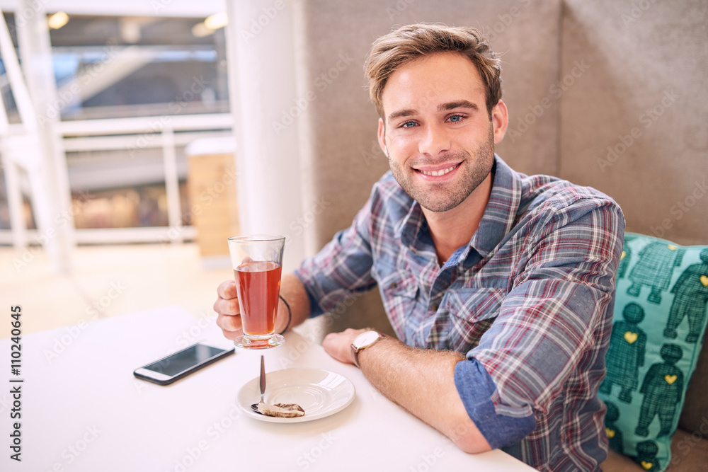 Good looking man looks straight at camera sitting in cafe Good looking man looks straight at camera sitting in cafe