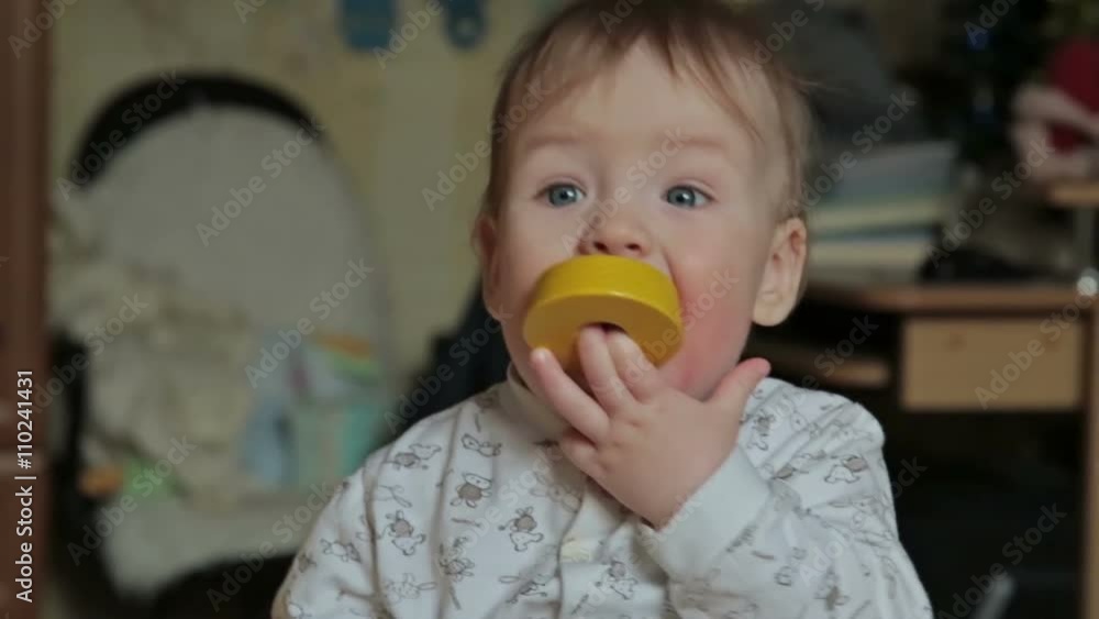 Baby boy takes in her mouth bright toy Baby boy takes in her mouth bright toy