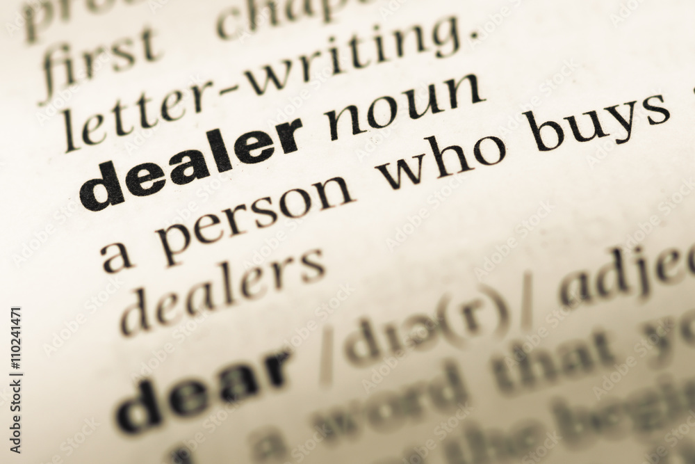 Obraz premium Close up of old English dictionary page with word dealer
