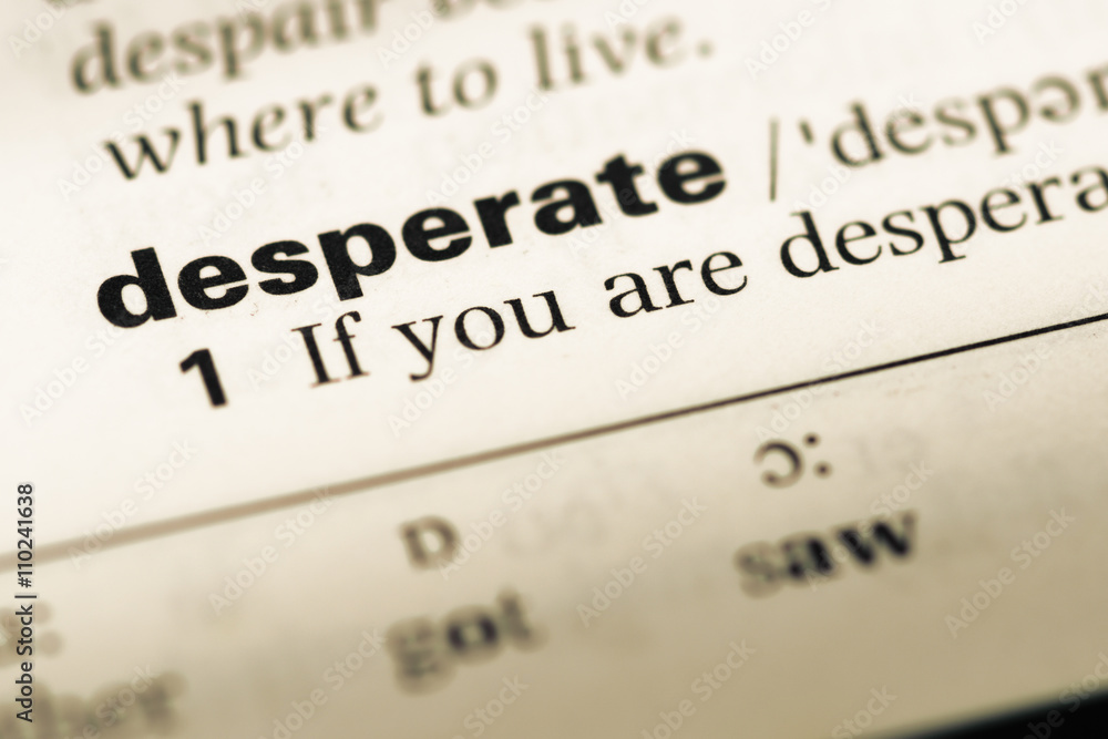 Close up of old English dictionary page with word desperate Close up of old English dictionary page with word desperate