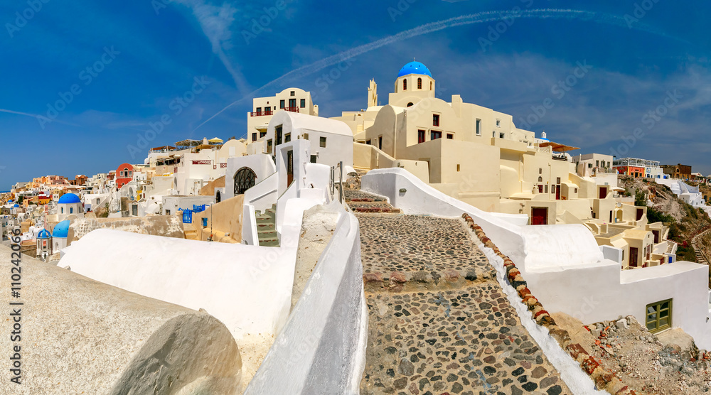 Picturesque panorama, Old Town of Oia or Ia on the island Santorini, white houses and church with blue domes, Greece