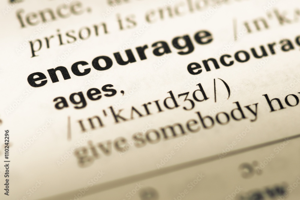 Close up of old English dictionary page with word encourage Close up of old English dictionary page with word encourage