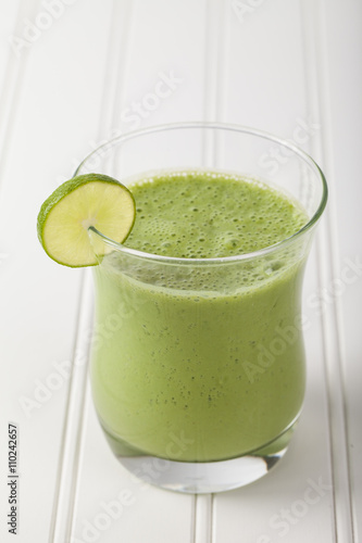 Lime green smoothie on white wood