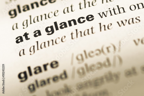 Fotografi Close up of old English dictionary page with word at a glance