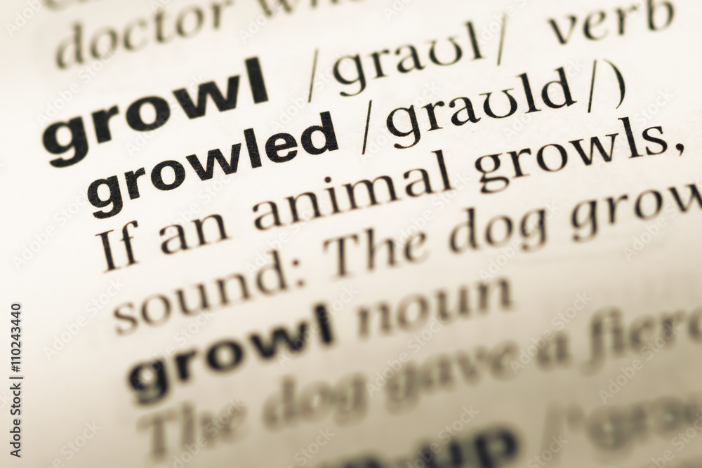 Close up of old English dictionary page with word growled Close up of old English dictionary page with word growled