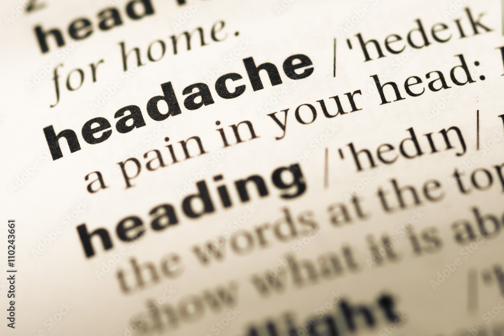 Close up of old English dictionary page with word headache Close up of old English dictionary page with word headache