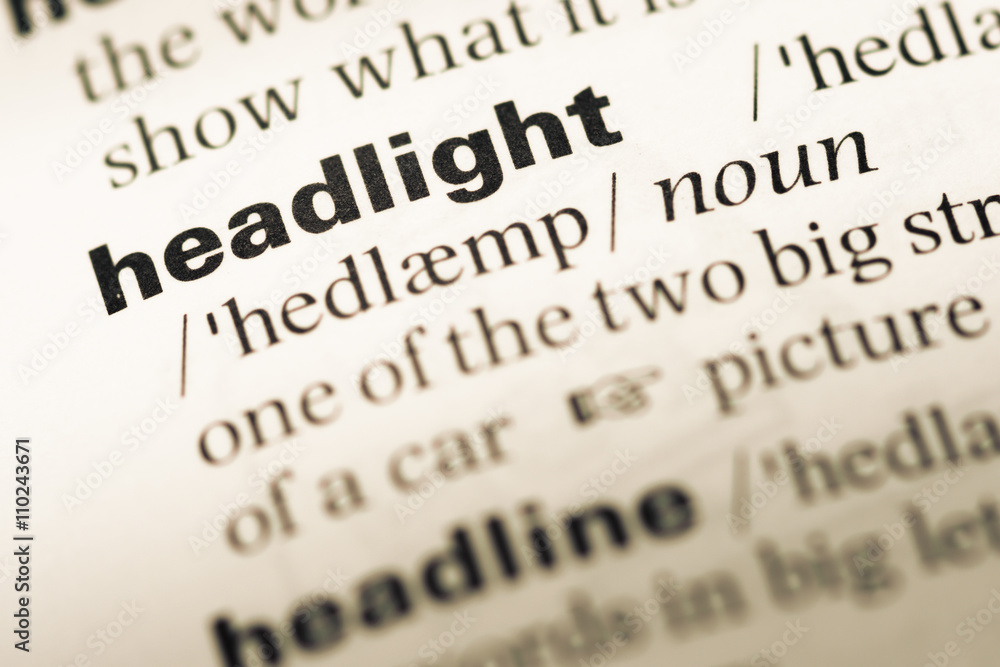Close up of old English dictionary page with word headlight Close up of old English dictionary page with word headlight
