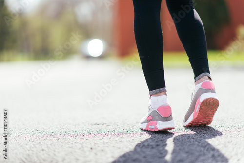 Runner feet running on road closeup on shoe. woman fitness jog workout welness concept. © lumenphotos