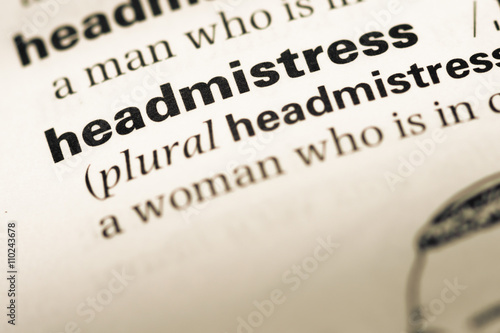 Close up of old English dictionary page with word headmistress