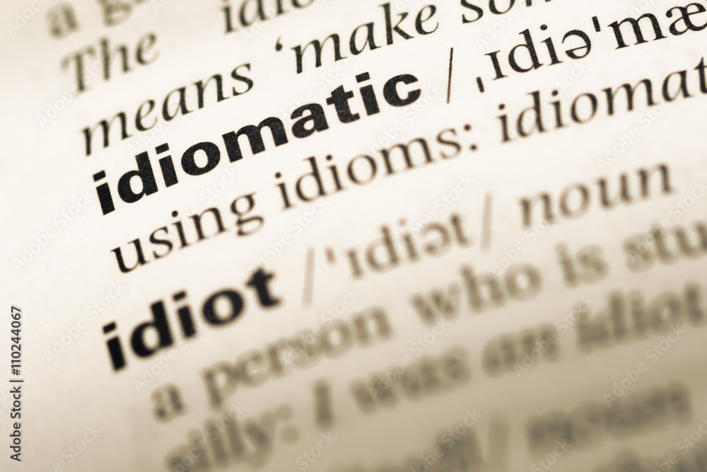 Close up of old English dictionary page with word idiomatic Close up of old English dictionary page with word idiomatic