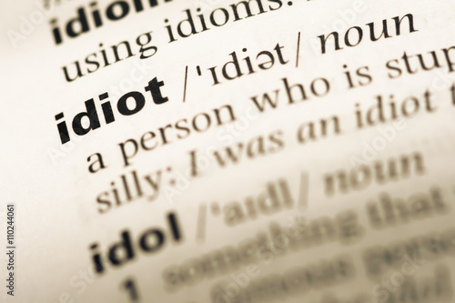 Close up of old English dictionary page with word idiot
