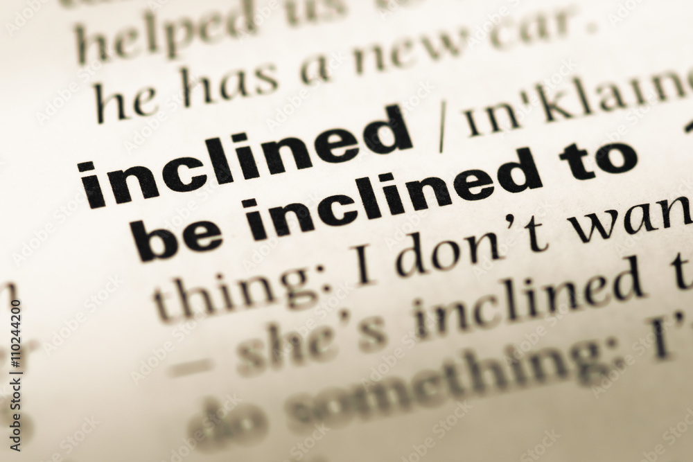 Obraz premium Close up of old English dictionary page with word inclined