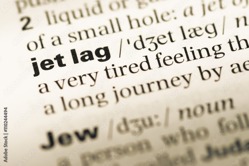 Close up of old English dictionary page with word jet lag Close up of old English dictionary page with word jet lag