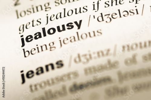 Fototapet Close up of old English dictionary page with word jealousy
