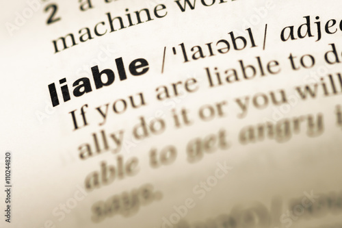 Close up of old English dictionary page with word liable