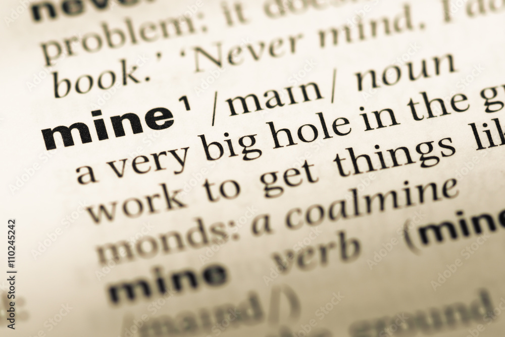 Close up of old English dictionary page with word mine Close up of old English dictionary page with word mine