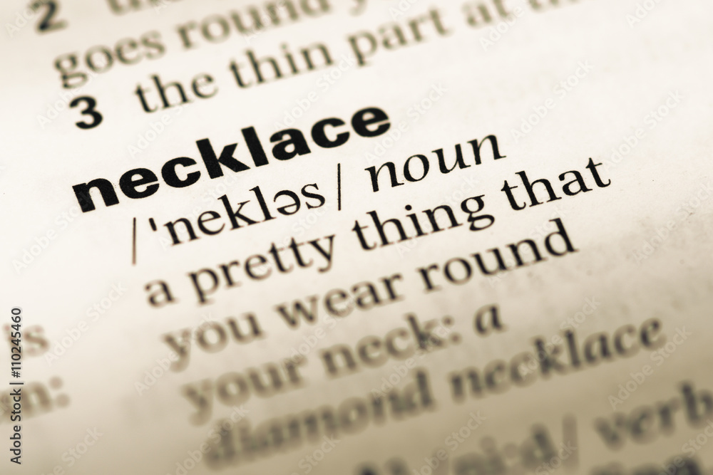 Close up of old English dictionary page with word necklace Close up of old English dictionary page with word necklace