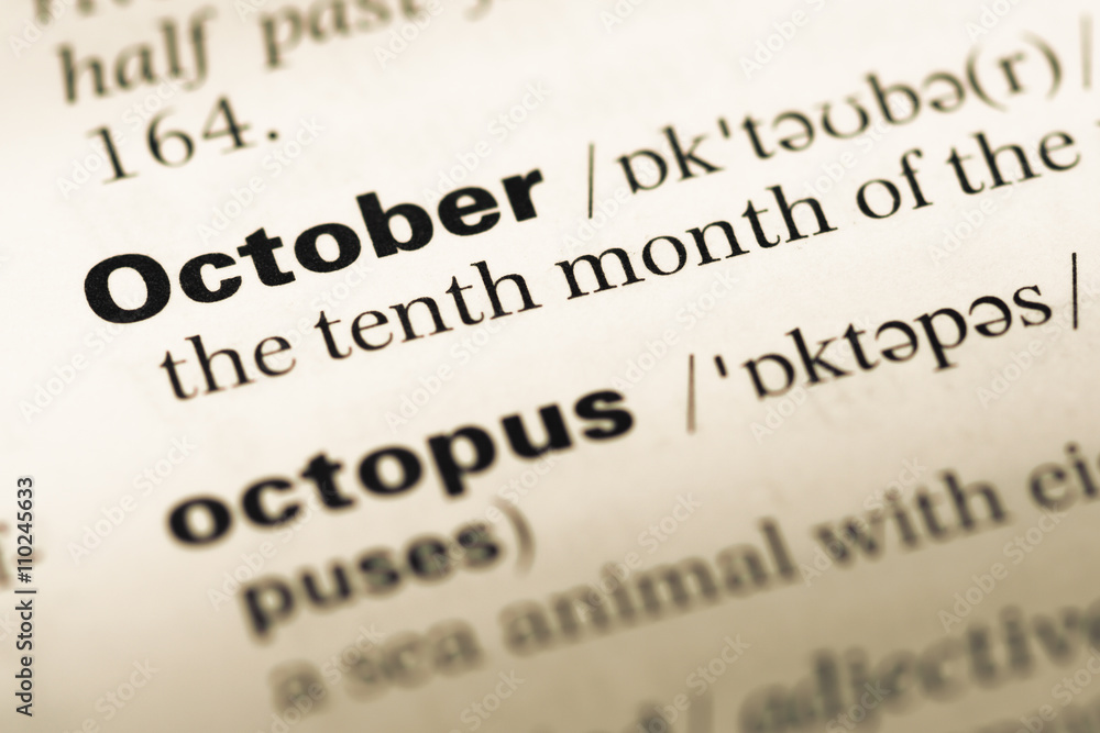 Close up of old English dictionary page with word october Close up of old English dictionary page with word october