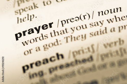 Close up of old English dictionary page with word prayer
