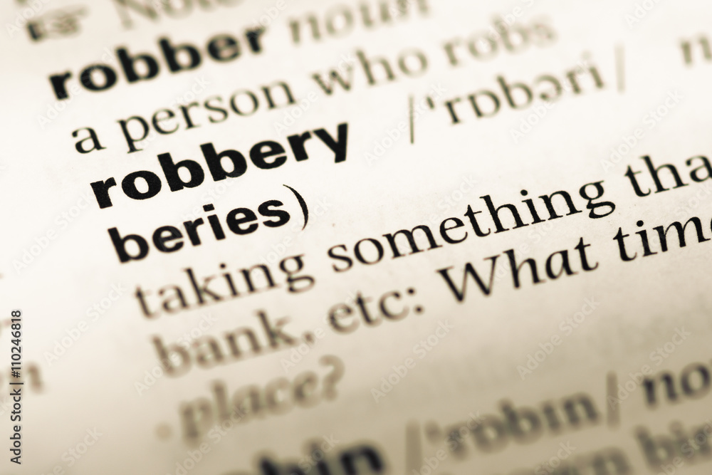 Close up of old English dictionary page with word robbery Close up of old English dictionary page with word robbery