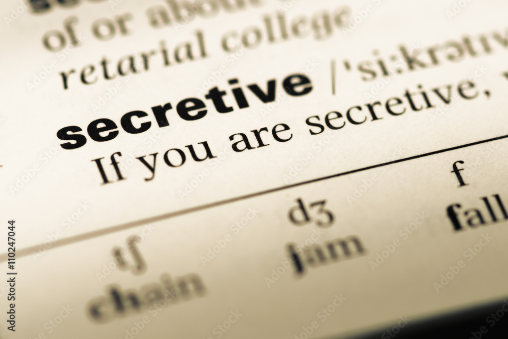 Close up of old English dictionary page with word secretive Close up of old English dictionary page with word secretive